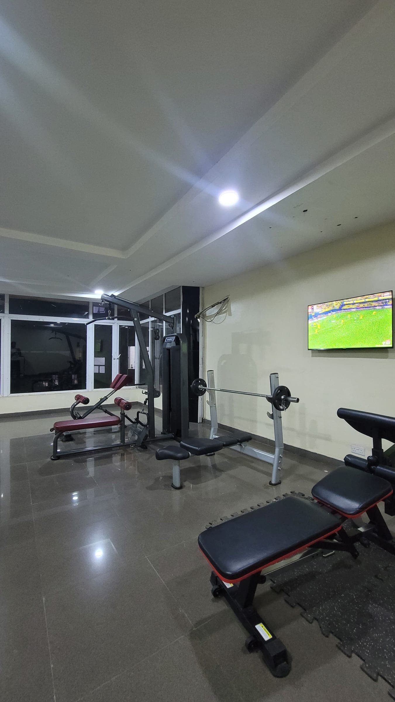 Benches and cardio equipment along the gym wall